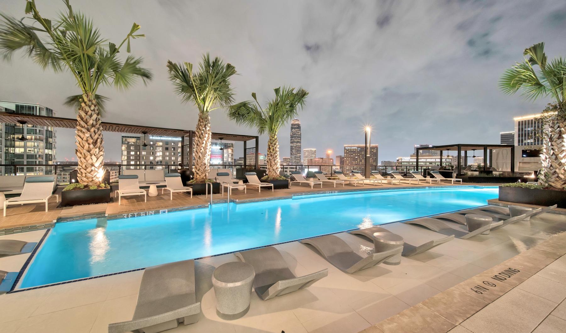 Relax and unwind poolside a pool with lounge chairs around it